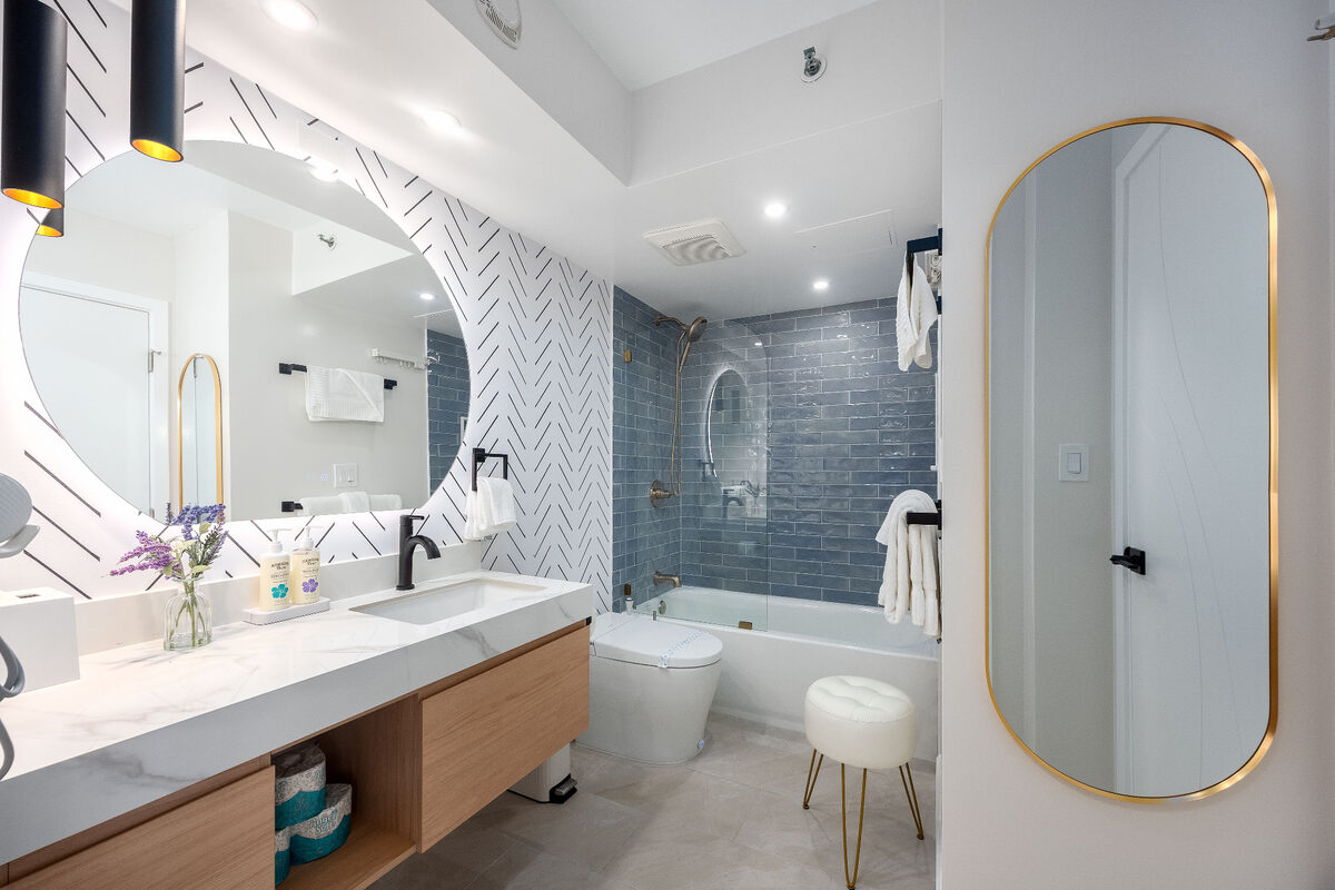 Bright vacation rental bathroom with fresh white towels and organized vanity