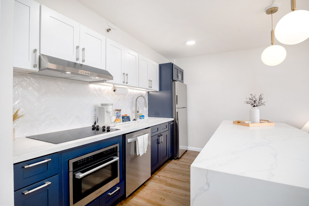 Clean vacation rental kitchen with blue cabinets and clear countertops