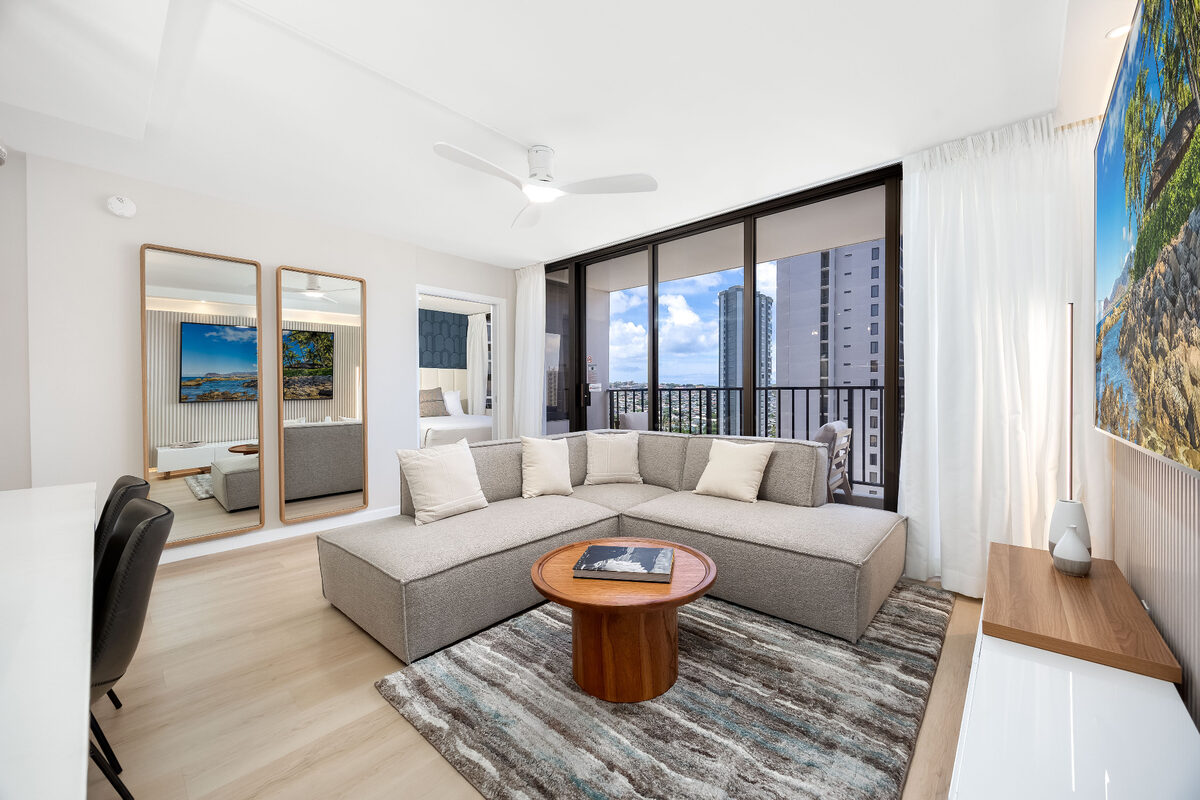 Spacious vacation rental living room with neatly arranged seating and balcony view